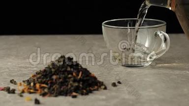 茶道。 绿茶被倒入一个透明的杯子里，放在靠近绿茶堆的黑色背景的桌子上